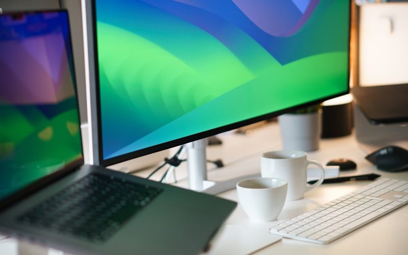 a desk with a laptop and a monitor on it